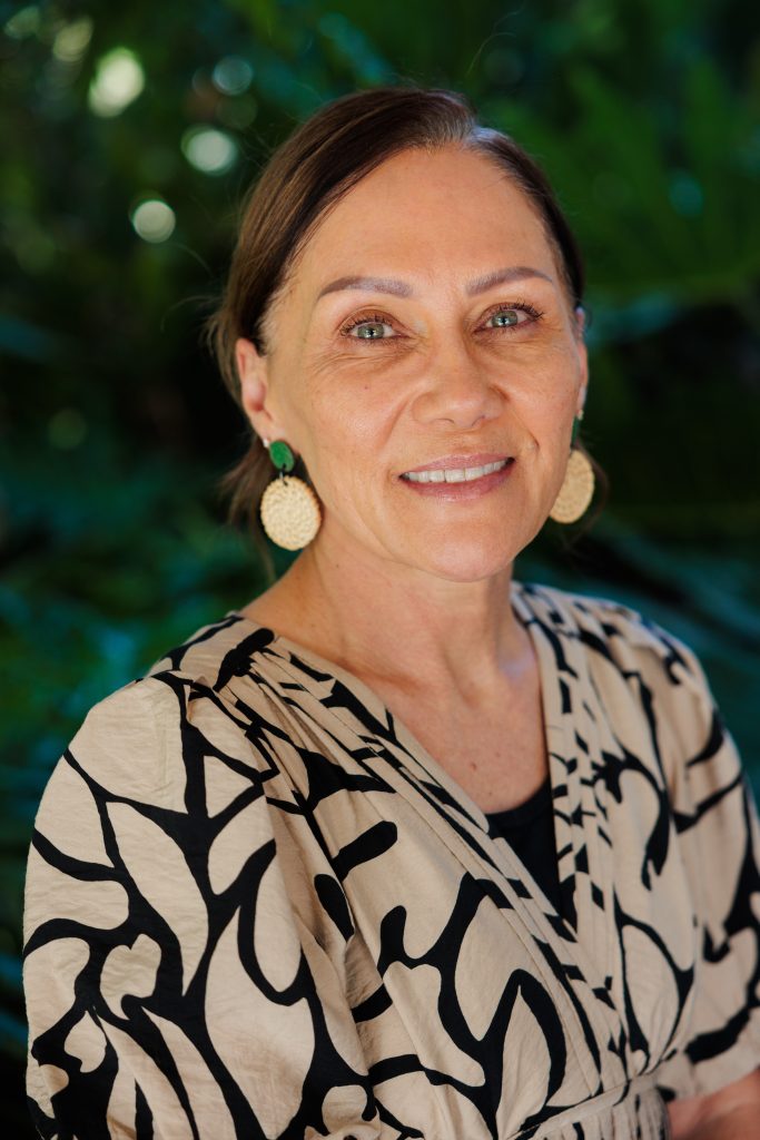 Donna Murray - woman smiling with round earrings.