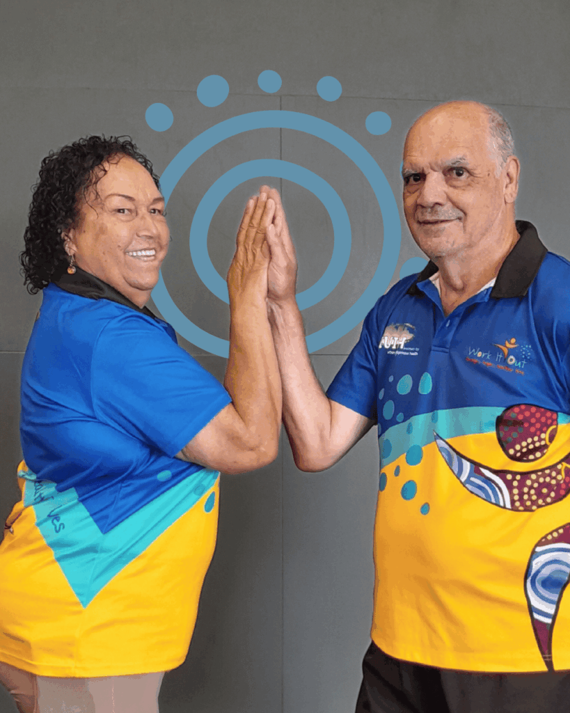 Two Work It Out participants standing facing each other, gently pressing their palms together to demonstrate the Stretch of the Month exercise - the Partner Pec Stretch.