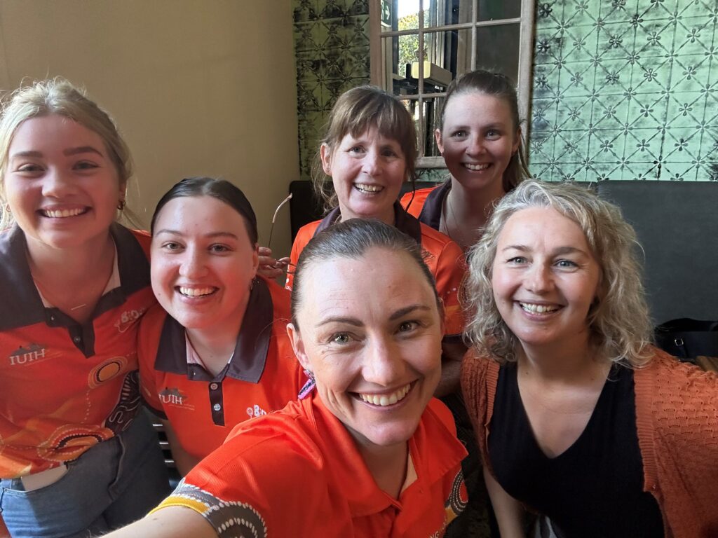 Michelle Warriner and her fellow midwives and orange BiOC uniform shirts - they all look happy.